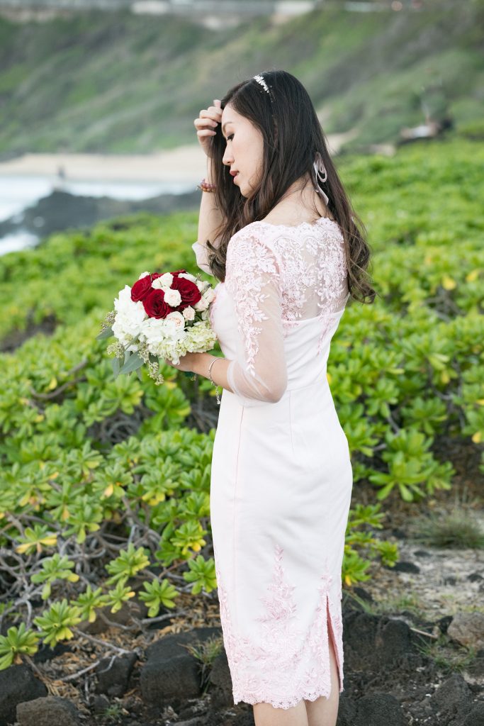 bride with flower bouquet taking photos at Hawaii beach